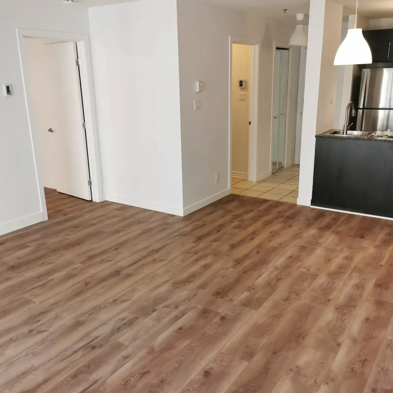 Intérieur d'appartement rafraîchi : nouveau plancher imitation bois, peinture fraîche et moulures neuves