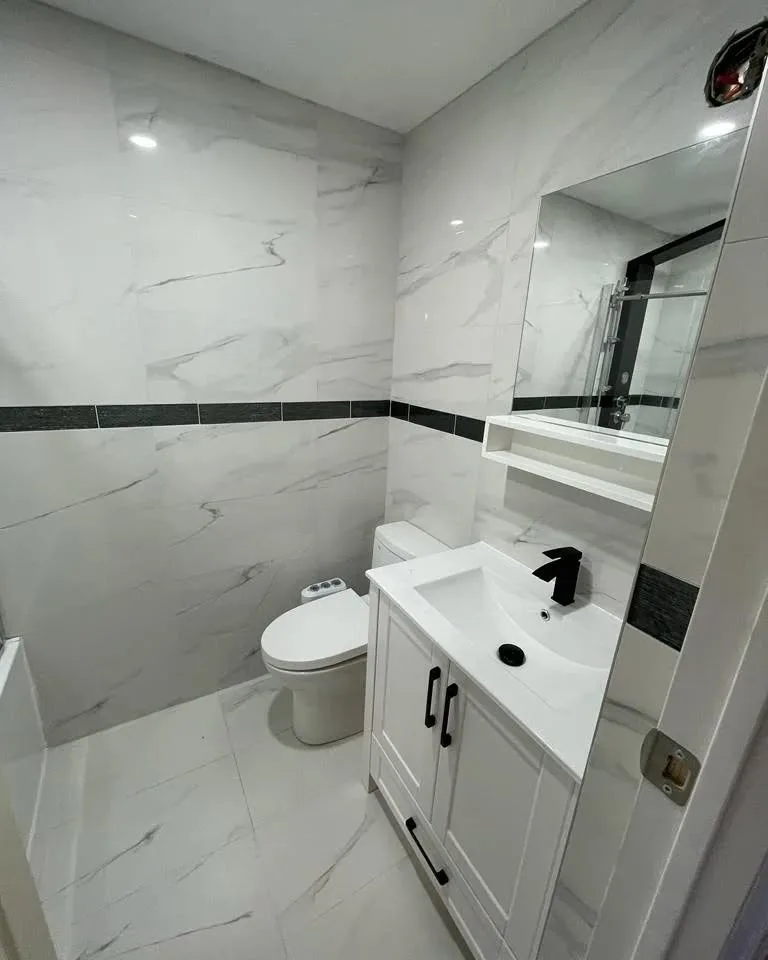 Salle de bain rénovée en une semaine, finie en porcelaine effet marbre avec robinetterie noire