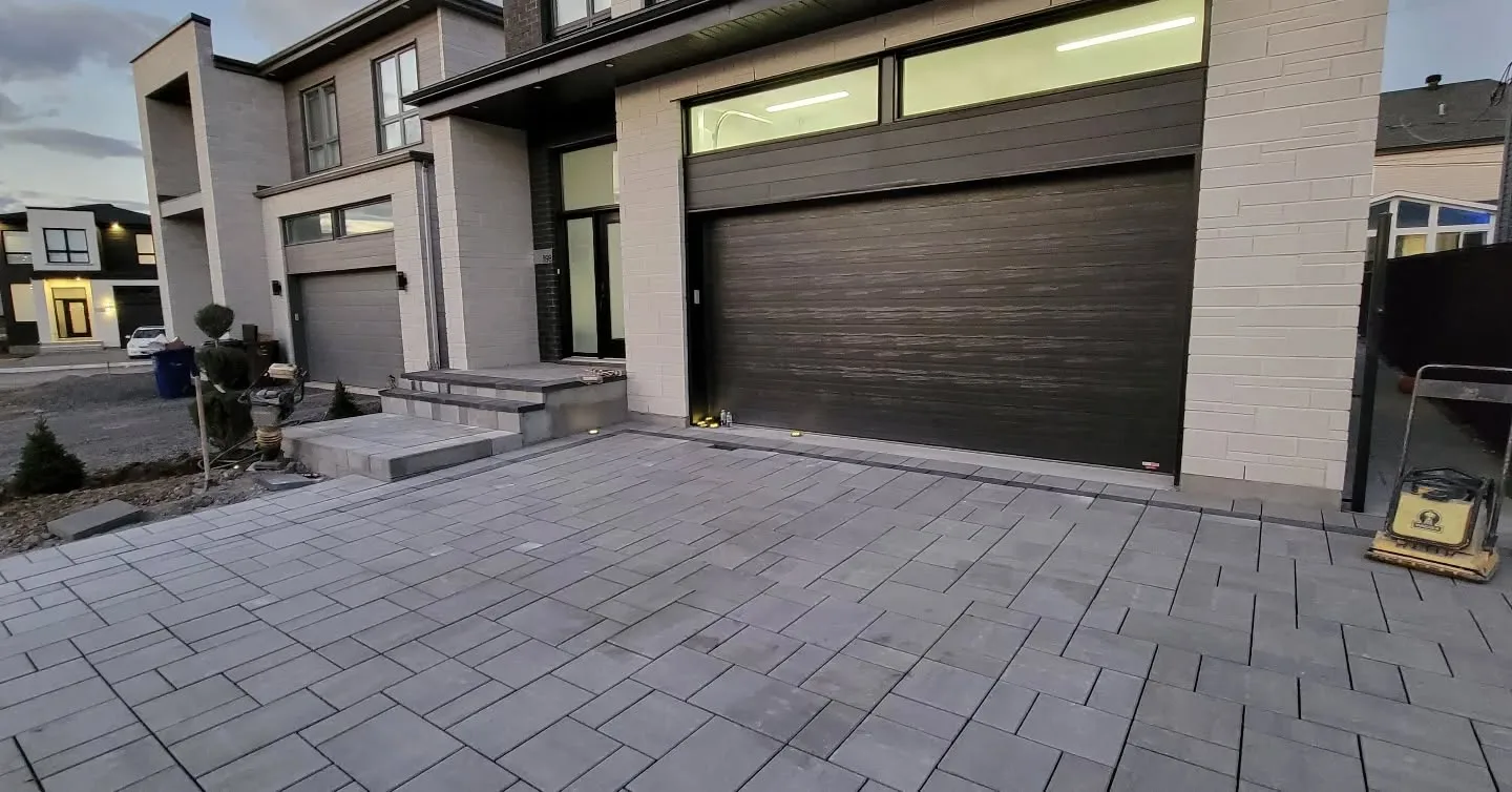 Façade de maison avec une nouvelle entrée en pavé uni au crépuscule