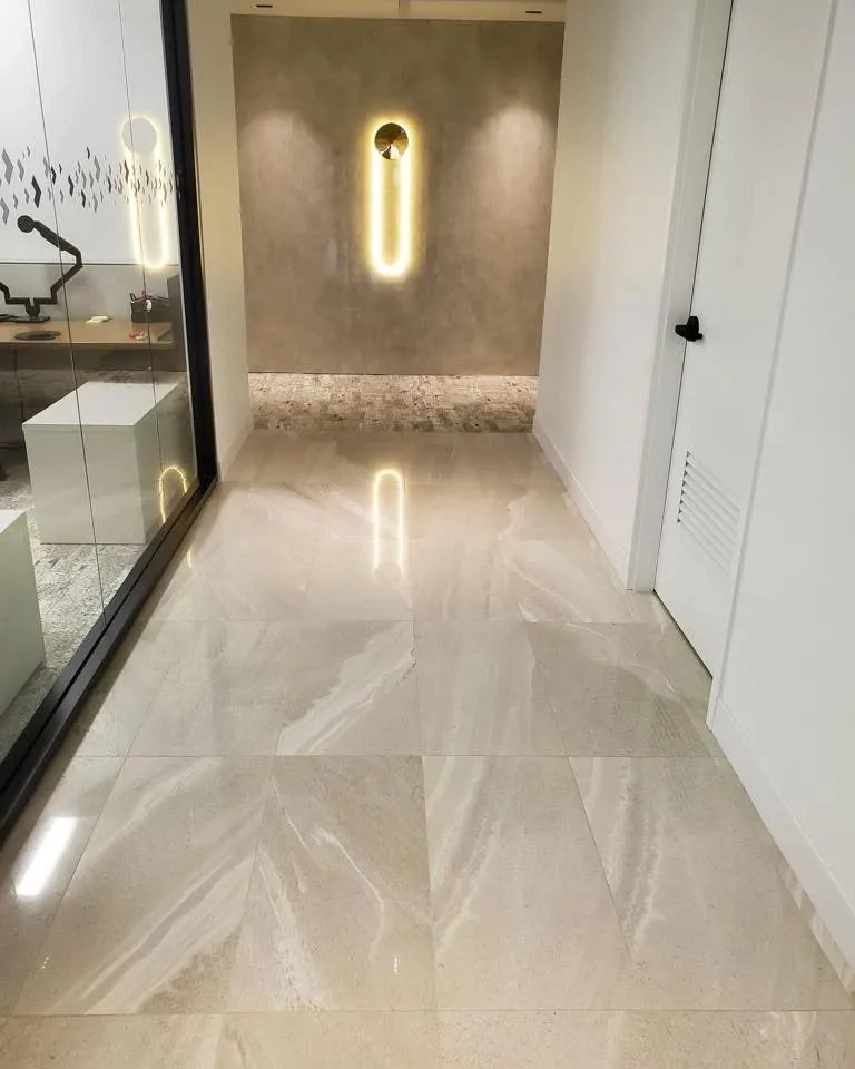 Hall d'entrée fini en porcelaine grand format effet marbre, avec mur décoratif rétroéclairé