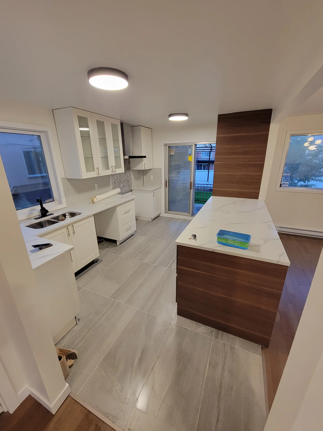 The finished kitchen — white cabinetry, walnut island, quartz counters
