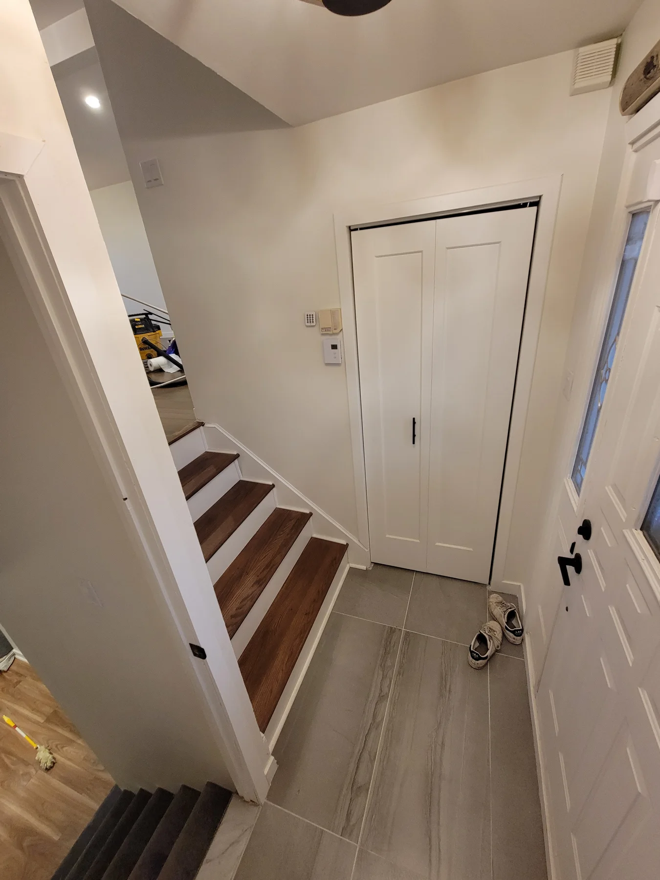 Front entry in ceramic tile, open to the upper floor