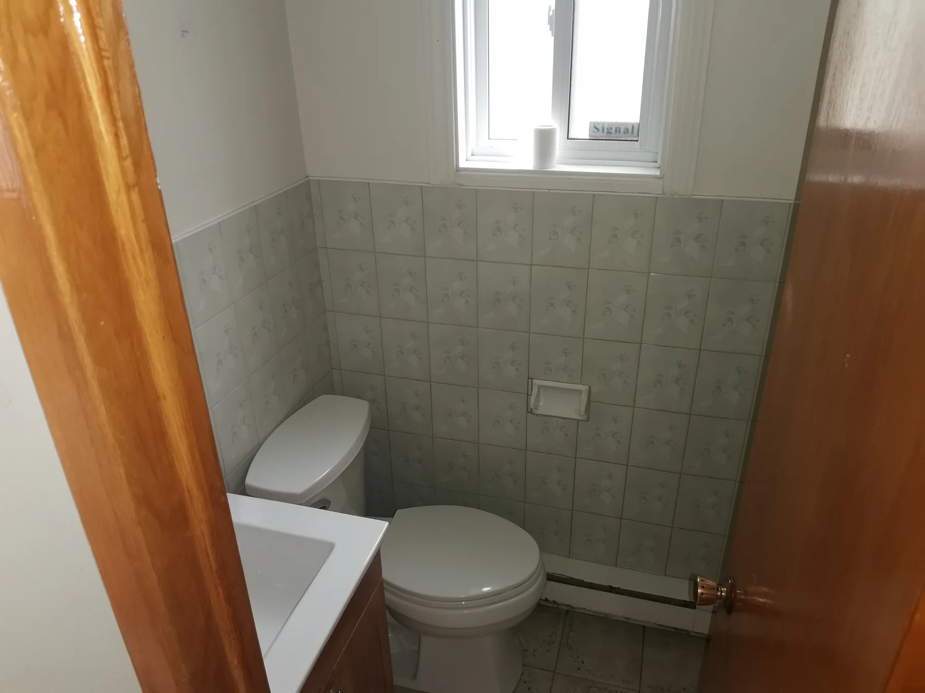 Powder room before: mint-green floral tiles straight out of another era