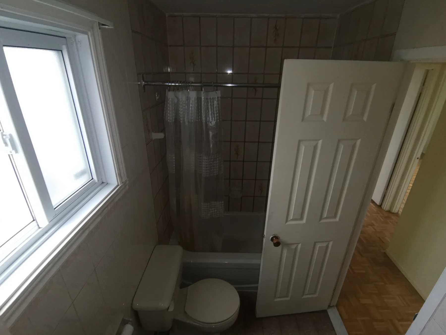 Main bathroom before: brown wheat-motif tiles around the old tub